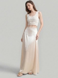 Detail of high-waisted champagne satin maxi skirt with elegant crochet hollow vest