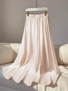 Detail of soft champagne satin skirt showing elastic waist and smooth silky fabric texture