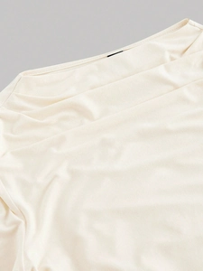Detailed close-up of cream knit long-sleeve top featuring premium ribbed fabric texture