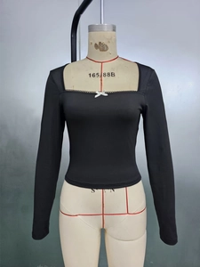 Detail of square neckline with small white bow on slim fit black long sleeve top