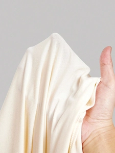 Detailed view of soft beige stretch fabric with smooth texture for long sleeve tops