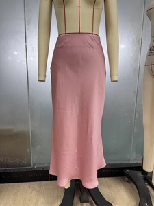 Vue détaillée du fini satiné rose lisse et du drapé fluide de cette jupe midi sirène