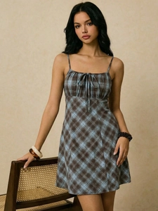 Detailed view of plaid mini dress featuring a drawstring bust and bow tie front accent