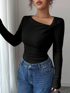 Détail d'un pull en maille côtelée ajusté avec encolure asymétrique à nœud élégant