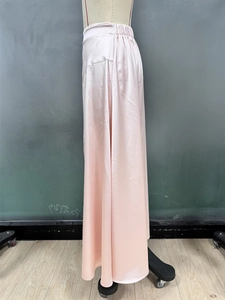 Detailed view of champagne satin midi skirt showing elastic high waist and silky texture