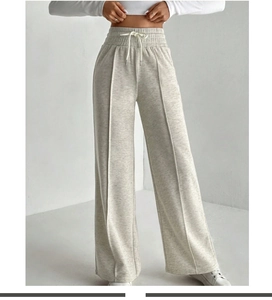 Détail du pantalon gris à jambes larges, taille haute avec cordon et couture avant