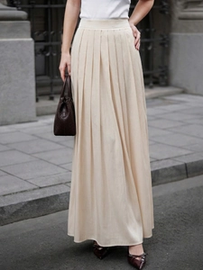 Detail showing the vertical pleated texture and elegant drape of this high-waisted beige skirt