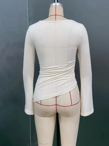 Rear view of off-white long sleeve top showing elastic fabric and back ripple texture