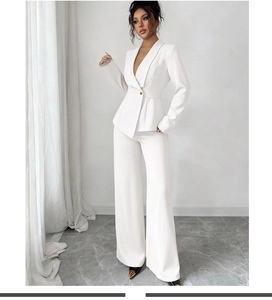 Détail du blazer blanc cintré avec bouton doré et pantalon assorti à taille haute