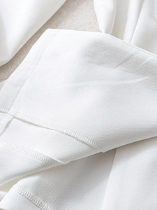 Λεπτομέρεια της υφής twill και των προσεγμένων ραφών στο στρίφωμα του λευκού σακακιού