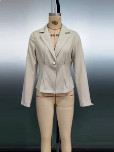 Détail du blazer crème montrant les plis à la taille et la fermeture à bouton unique
