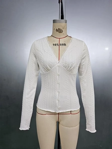 Close-up of slim-fit white V-neck top featuring textured fabric and delicate lace trim