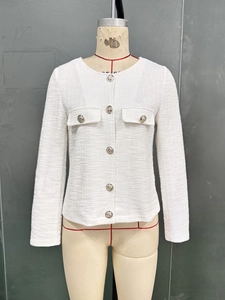 Detail of white tweed jacket featuring round neck and metallic buttons on female mannequin