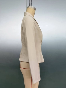 Vue latérale du blazer court ajusté beige sur un mannequin avec une coupe nette et élégante