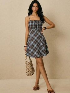 Detail of plaid mini dress showing spaghetti straps and adjustable drawstring neckline