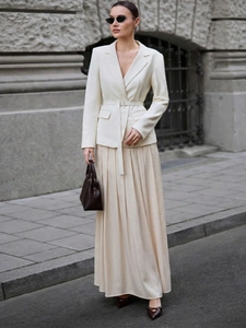Detail of elegant cream satin maxi skirt with high waist belt and pleated fabric design