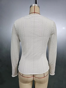 Detailed back view of white slim-fit top with textured knit fabric and lace V-neckline