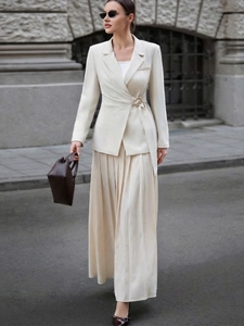 Detail of elegant cream satin maxi skirt with flowing drapes and side wrap buckle design