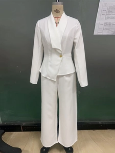 Détail d'un ensemble blazer blanc avec design asymétrique et bouton doré unique