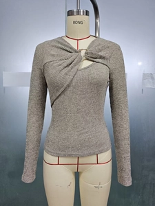 Detail of grey ribbed knit top featuring a twist knot neckline and metal ring accent