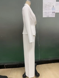 Détail d'un tailleur blanc pour femme avec bouton doré sur un présentoir mannequin