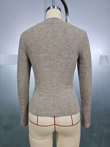 Close-up of slim fit knitted long sleeve top showing grey vertical ribbed texture back