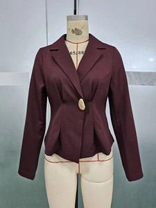 Detail of burgundy slim-fit blazer showing pleated waist design and decorative button