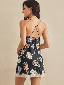 Détail du dos croisé d'une nuisette en satin noir à fleurs avec bordure en dentelle