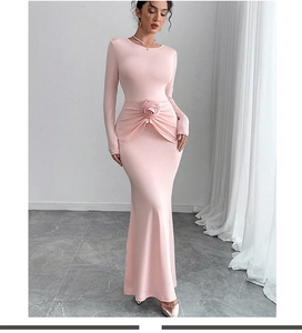 Détail d'une robe de soirée rose en tricot avec rose en tissu 3D et plis élégants
