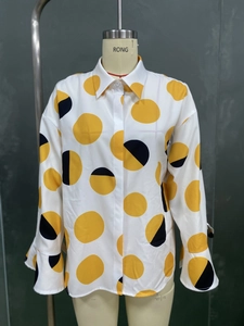 Détail de chemise à manches longues à pois avec motifs jaunes et poignets évasés élégants