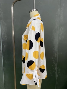 Détail de chemisier à pois pour femme avec poignets à nœuds papillon et tissu léger