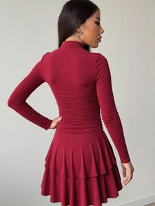 Abito bordeaux attillato a maniche lunghe con collo alto, arricciature e orlo a balze