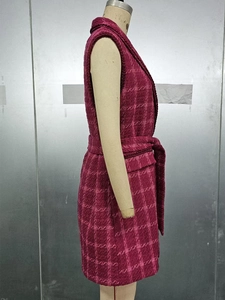 Macro detail of magenta plaid tweed waistcoat showing textured fabric and waist tie