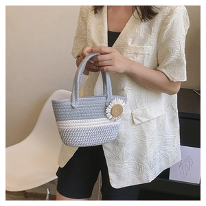 Dettaglio della borsa a spalla intrecciata grigia e bianca con decoro a margherita