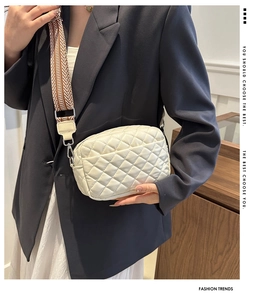 Chic white quilted crossbody bag featuring a geometric woven wide shoulder strap on model