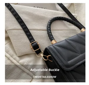 Detailed close-up of the adjustable golden buckle and black woven handle on the quilted bag