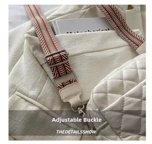 Close-up of adjustable silver metal buckle and patterned woven strap on quilted bag