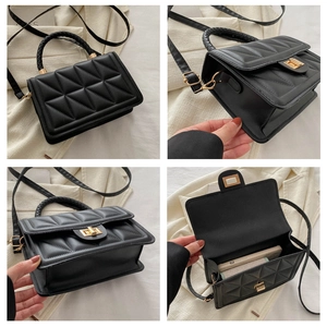Detail view of black quilted square bag with gold twist lock and woven handle