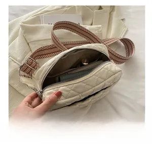 Detailed view of cream quilted crossbody bag interior capacity and wide shoulder strap