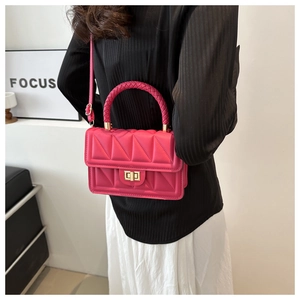 Detail of rose pink square bag featuring 3D triangle stitching and gold metal twist lock
