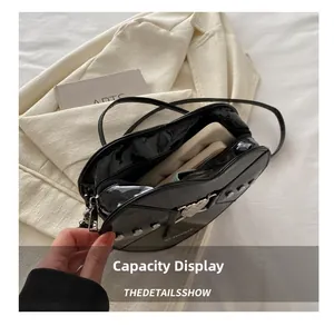 Capacité intérieure du sac cœur noir en cuir montrant le rangement d'un téléphone