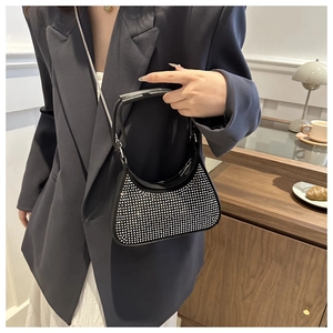 Détail d'un sac hobo noir orné de strass scintillants avec une bandoulière chaîne élégante
