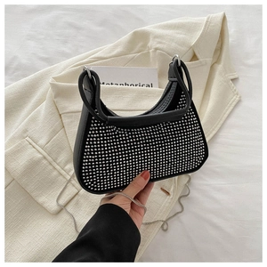 Détail du sac sous le bras en forme de croissant noir avec rivets et chaîne argentés