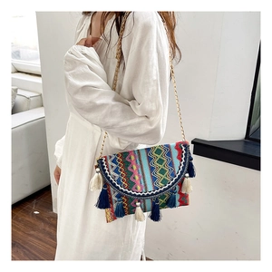 Detail of colorful bohemian crossbody bag featuring geometric jacquard and long tassels