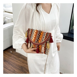 Close-up of ethnic woven pattern and colorful fringe tassels on a chain shoulder bag