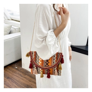 Detailed close-up of a bohemian crossbody bag with colorful tassels and chain strap