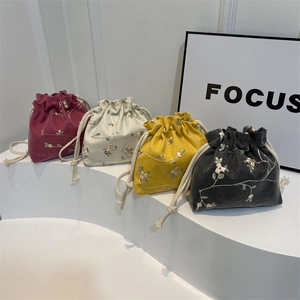 Borse a secchiello con coulisse e ricami floreali in quattro colori su espositore