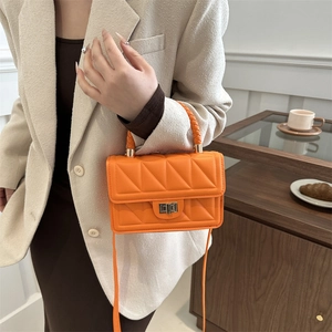 Orange quilted leather square crossbody bag with gold rotary clasp on model