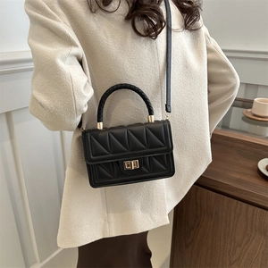 Minimalist black quilted crossbody bag with braided handle and gold metal twist lock