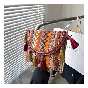 Close-up of ethnic woven crossbody bag featuring colorful geometric patterns and tassels